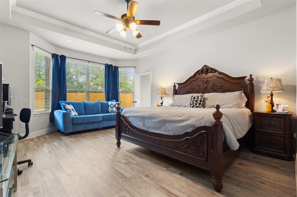 800 Goose Court Forney, TX 75126 - Photo 22 of 34 a spacious bedroom with a bed a couch and a large window