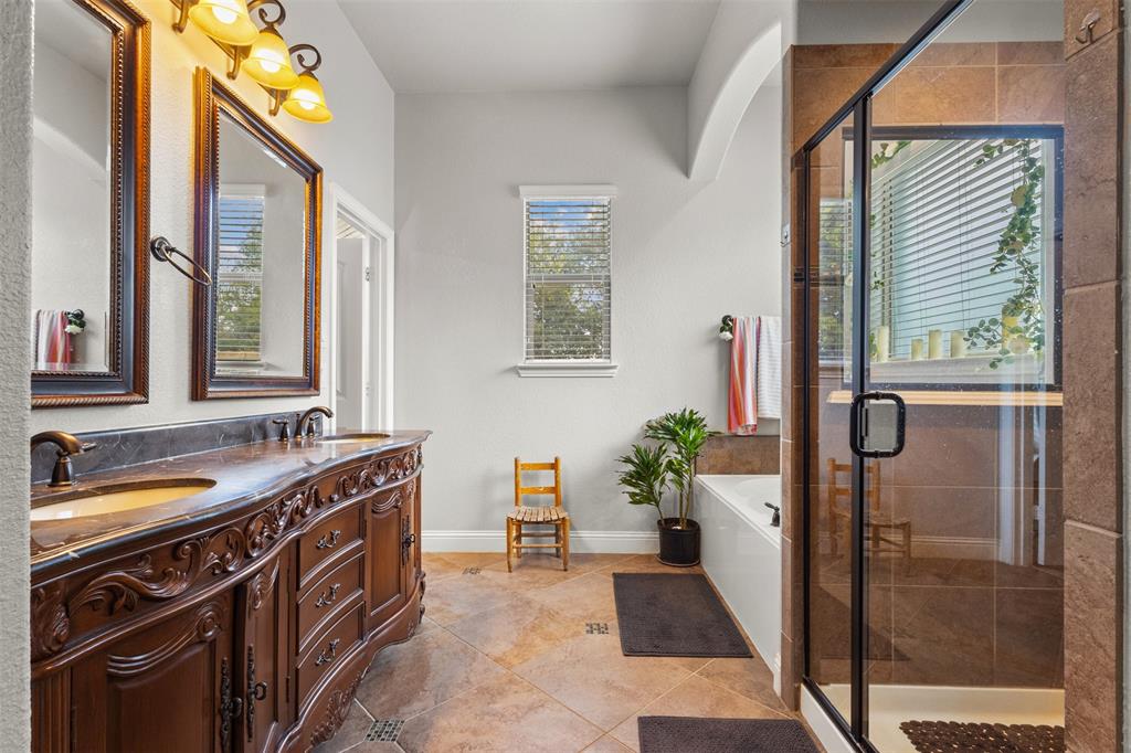 800 Goose Court Forney, TX 75126 - Photo 26 of 34 a bathroom with a tub a potted plant and a sink