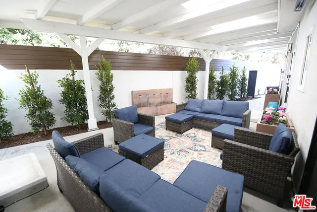 a outdoor living room with patio furniture and a potted plant