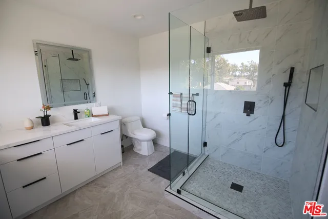 a bathroom with a double vanity sink toilet and shower