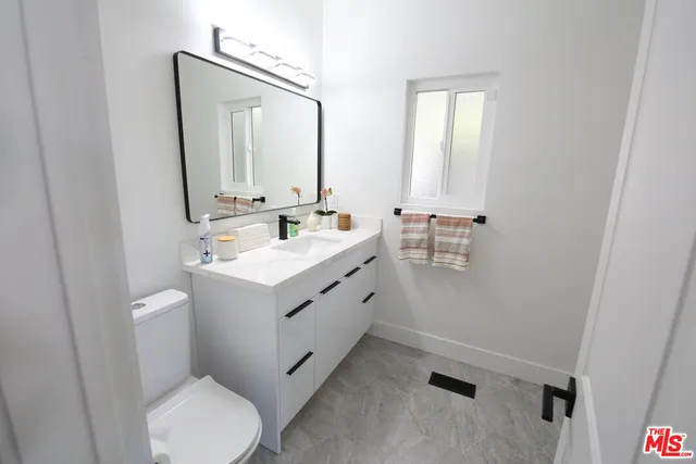 a bathroom with a toilet sink and mirror