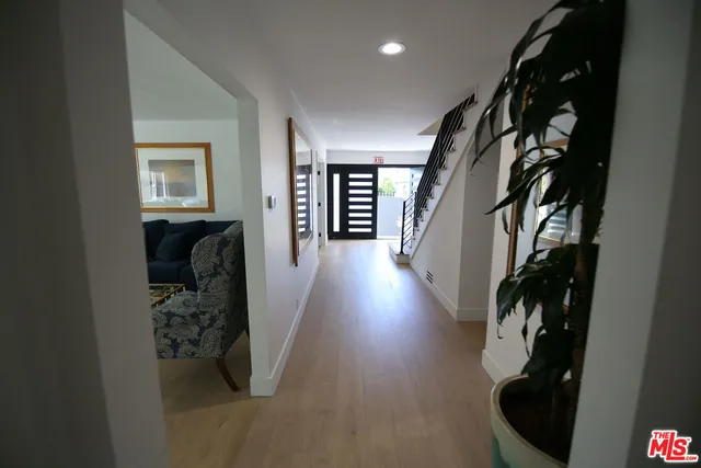 a view of a hallway with wooden floor and stairs