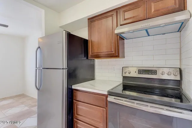 a kitchen with a refrigerator and a stove