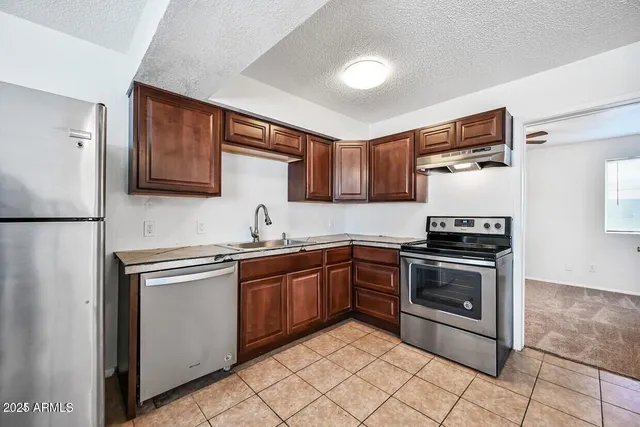 a kitchen with stainless steel appliances granite countertop a stove sink and cabinets