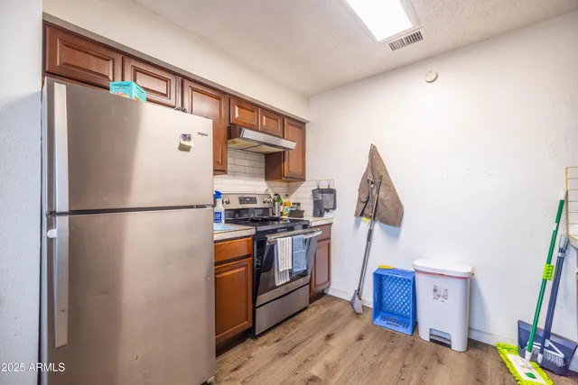 a kitchen with stainless steel appliances granite countertop a refrigerator and a stove