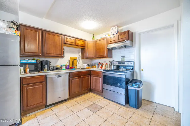 a kitchen with stainless steel appliances granite countertop a stove top oven a sink dishwasher and cabinets