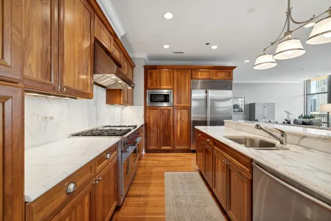 a kitchen with stainless steel appliances granite countertop a sink and a refrigerator