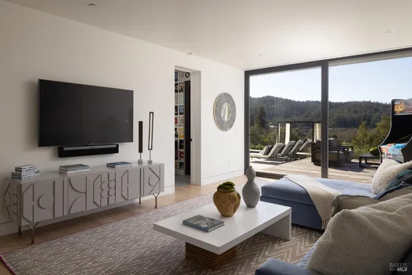 a living room with furniture a flat screen tv and a large window