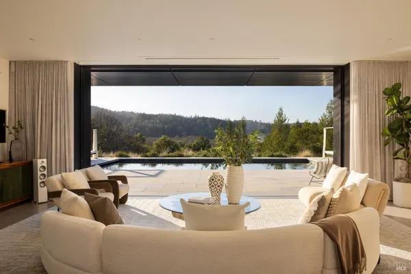 a living room with couches a coffee table and a large window with outer view