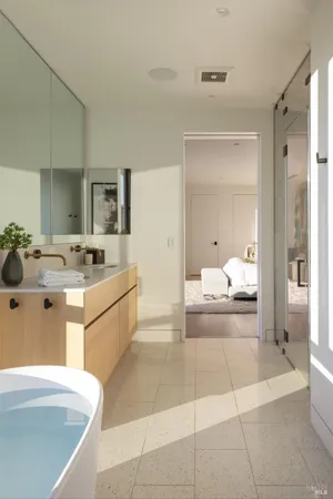 a large white bathroom with a double vanity sink a mirror and a bathtub