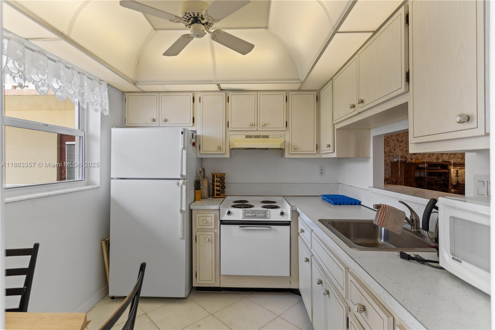 a kitchen with a sink a refrigerator a stove and cabinets