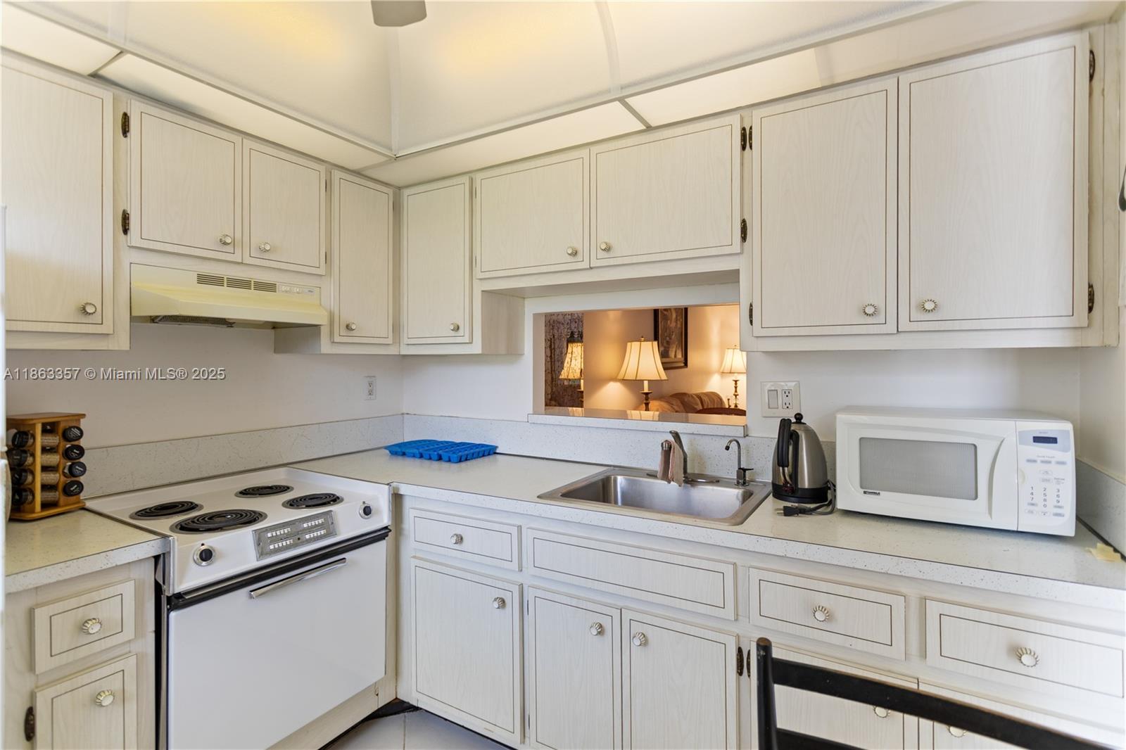 4299 Northwest 16th Street, Unit 210 Lauderhill, FL 33313 - Photo 2 of 37 a kitchen with white cabinets and white appliances