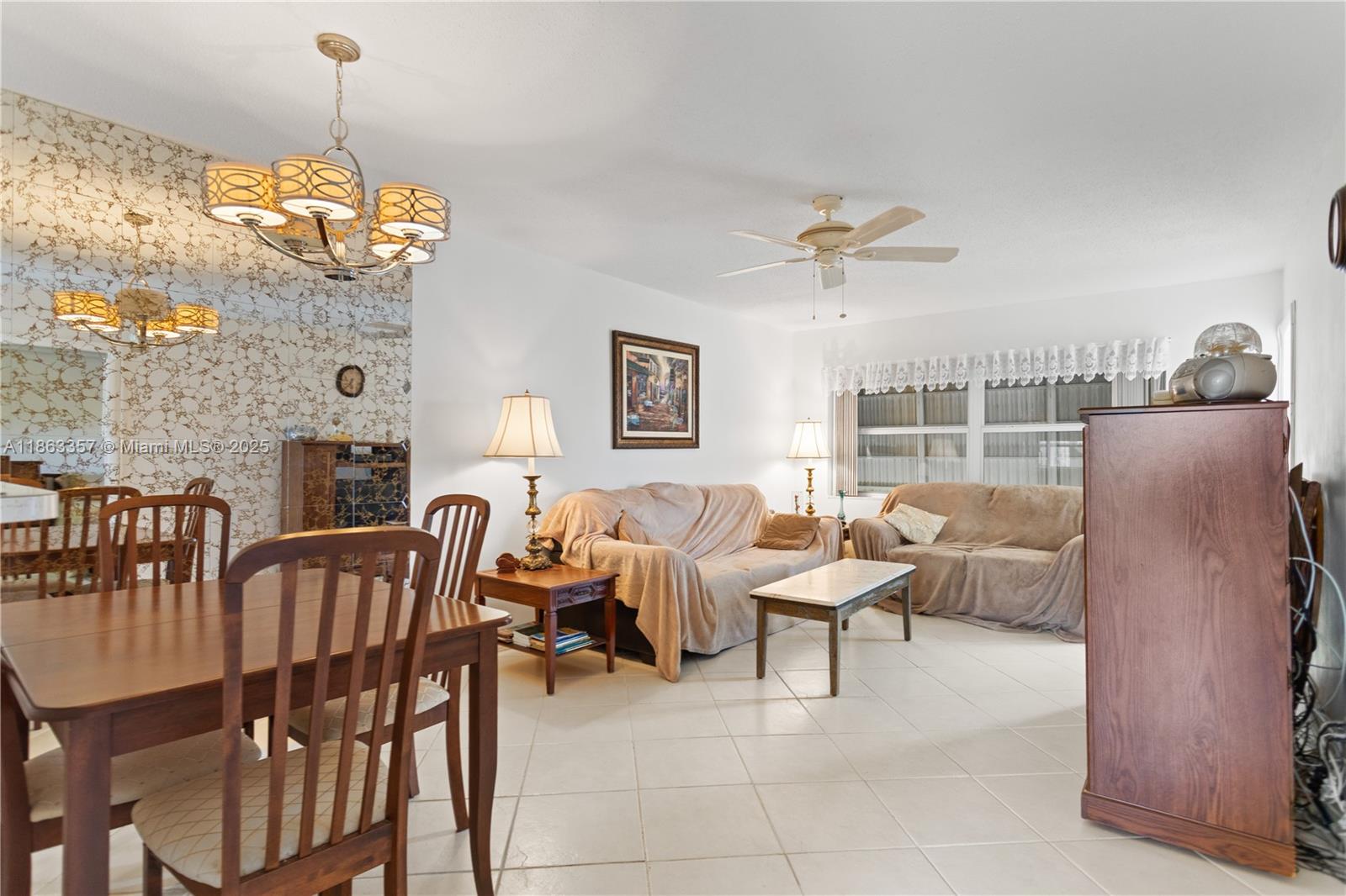 4299 Northwest 16th Street, Unit 210 Lauderhill, FL 33313 - Photo 4 of 37 a living room with furniture two window and a chandelier
