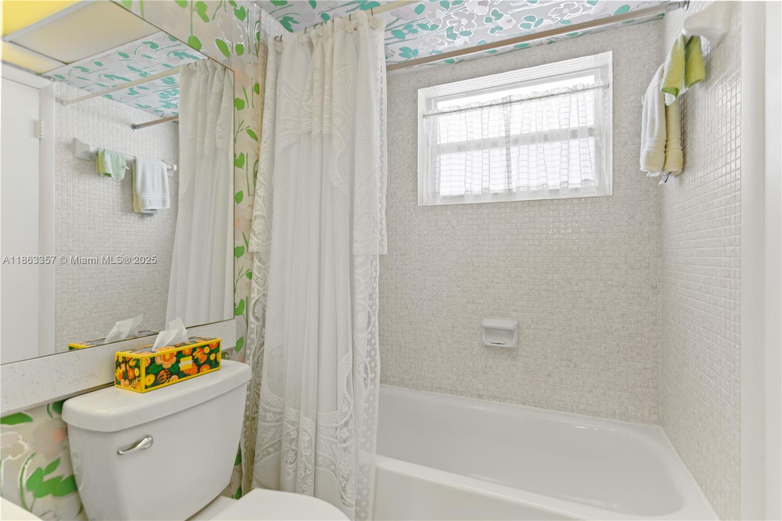 4299 Northwest 16th Street, Unit 210 Lauderhill, FL 33313 - Photo 10 of 37 a white bath tub sitting next to a white toilet and a shower curtain