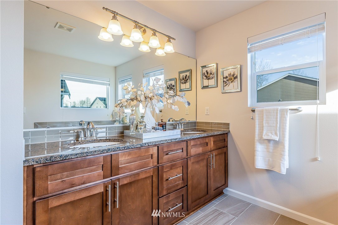 4303 Riverfront Boulevard Everett, WA 98203 - Photo 37 of 40 a bathroom with a granite countertop sink a mirror and a shower