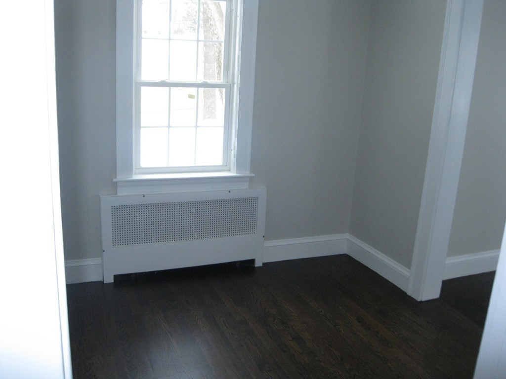 83 Flagg Street Worcester, MA 01602 - Photo 11 of 25 an empty room with wooden floor and windows