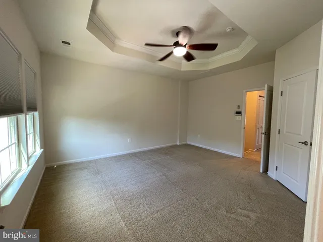 en empty room with windows and ceiling fan
