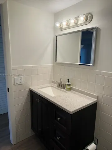 a bathroom with a sink vanity and a mirror