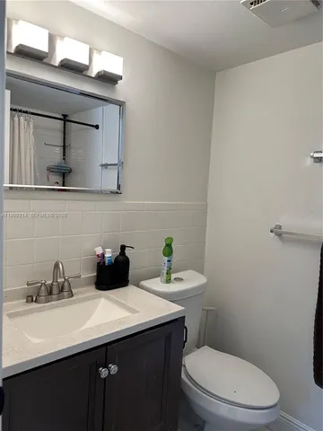 a bathroom with a sink a toilet and mirror