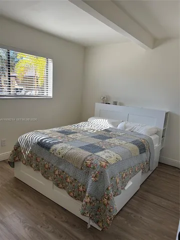 a large bed sitting in a bedroom next to a window