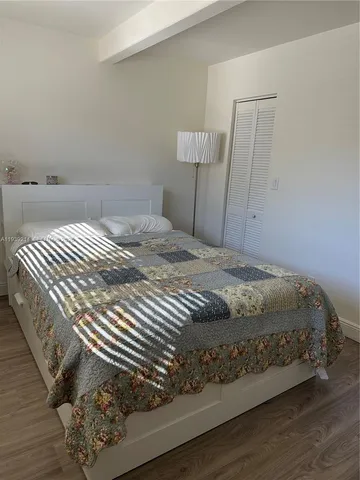 a bedroom with a bed and a wooden floor