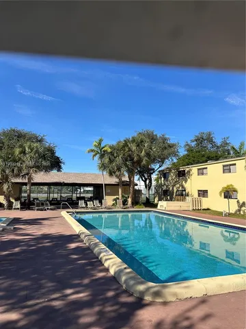 a view of swimming pool with outdoor seating and yard