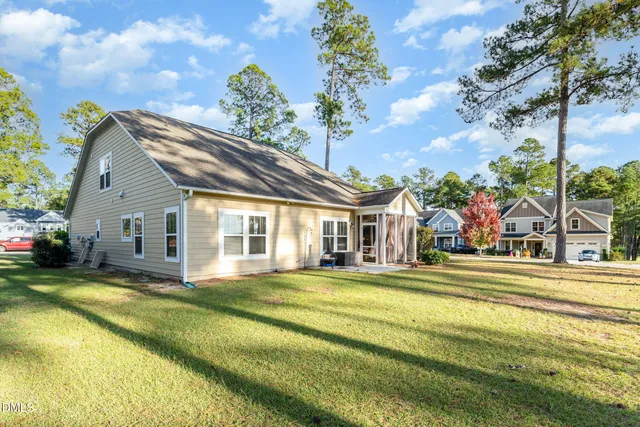 a view of a house with a big yard and large trees