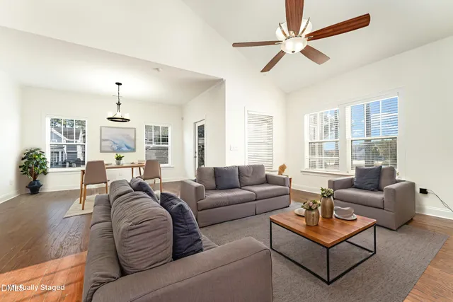 a living room with furniture a ceiling fan and a window
