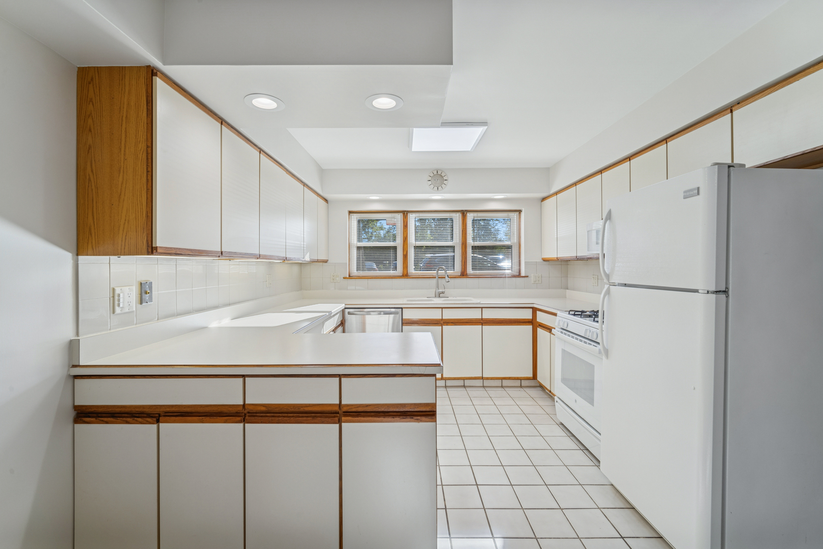 6800 North Overhill Avenue, Unit 1A Chicago, IL 60631 - Photo 7 of 20 a white kitchen with a sink and refrigerator