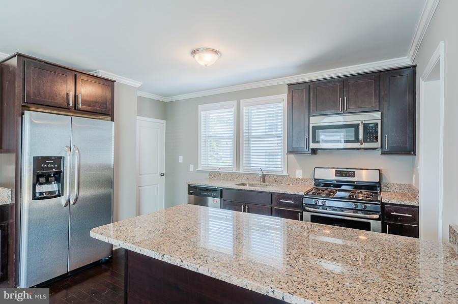 32 Midship Road Dundalk, MD 21222 - Photo 8 of 30 a kitchen with granite countertop a refrigerator and a stove top oven