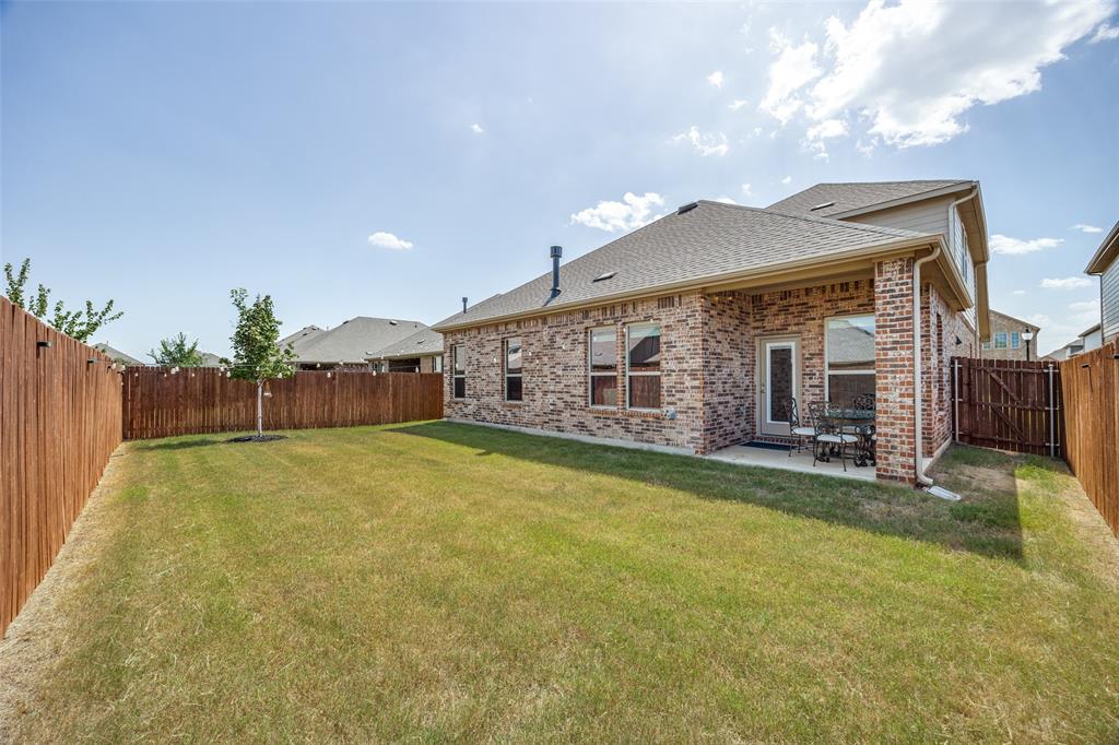 3816 Blacksmith Road Aubrey, TX 76227 - Photo 21 of 30 Fenced backyard featuring a manicured lawn, brick exterior, and covered patio