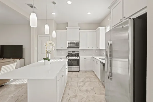 a kitchen with kitchen island a sink stainless steel appliances and cabinets