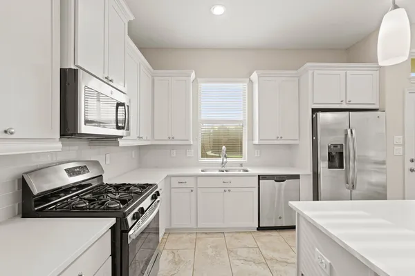 a kitchen with stainless steel appliances white cabinets and a sink