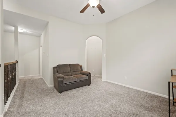 a living room with furniture and a ceiling fan