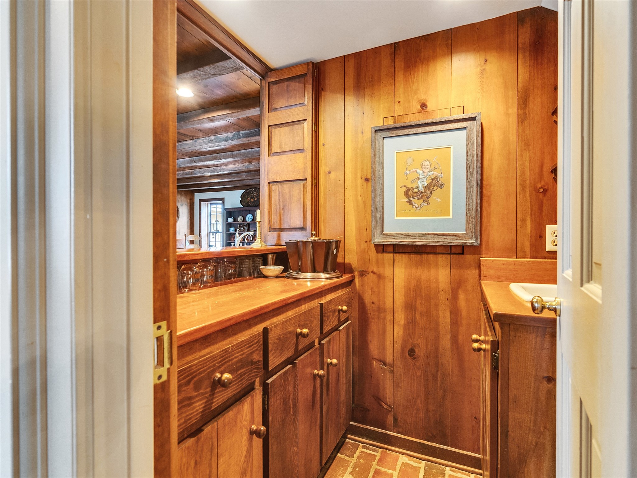 5212 Strack Road Houston, TX 77069 - Photo 11 of 42 Tucked conveniently between the formal rooms, the wet bar features custom wood cabinetry and brick flooring. Adjacent to the the wet bar is a brick hallway that features a poweder bath.