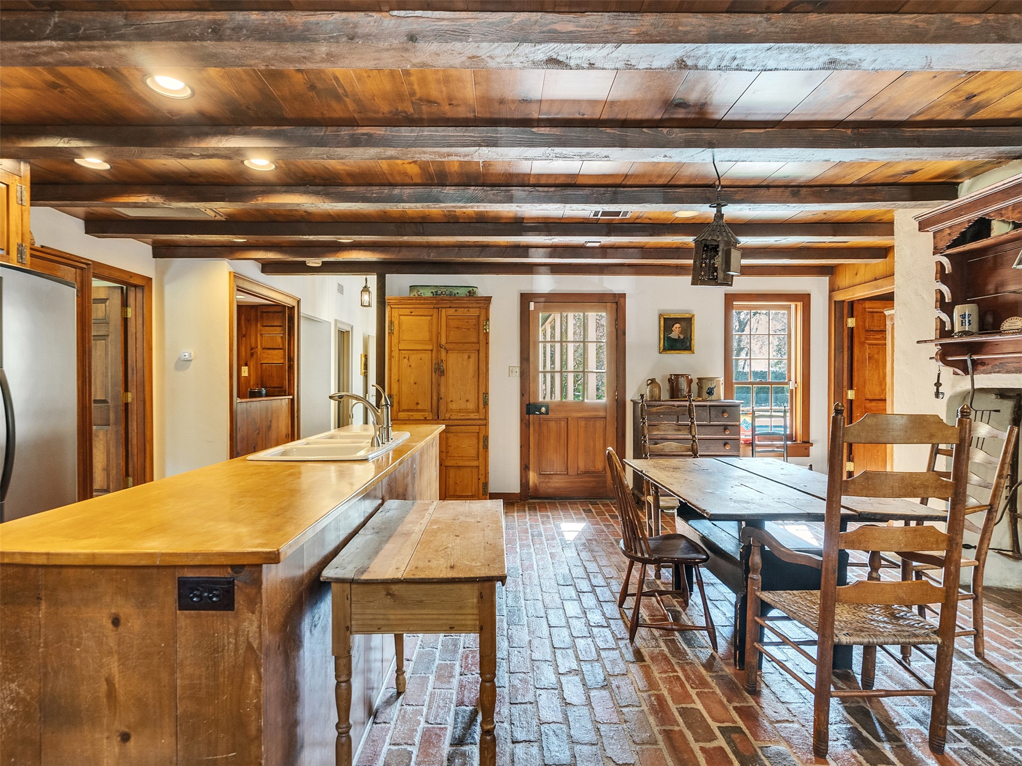5212 Strack Road Houston, TX 77069 - Photo 14 of 42 Exposed ceiling beams bring a sense of rustic feel where the woodwork contrasts beautifully with the brick flooring, creating a relaxed yet high-end environment for casual meals and large-scale hosting.