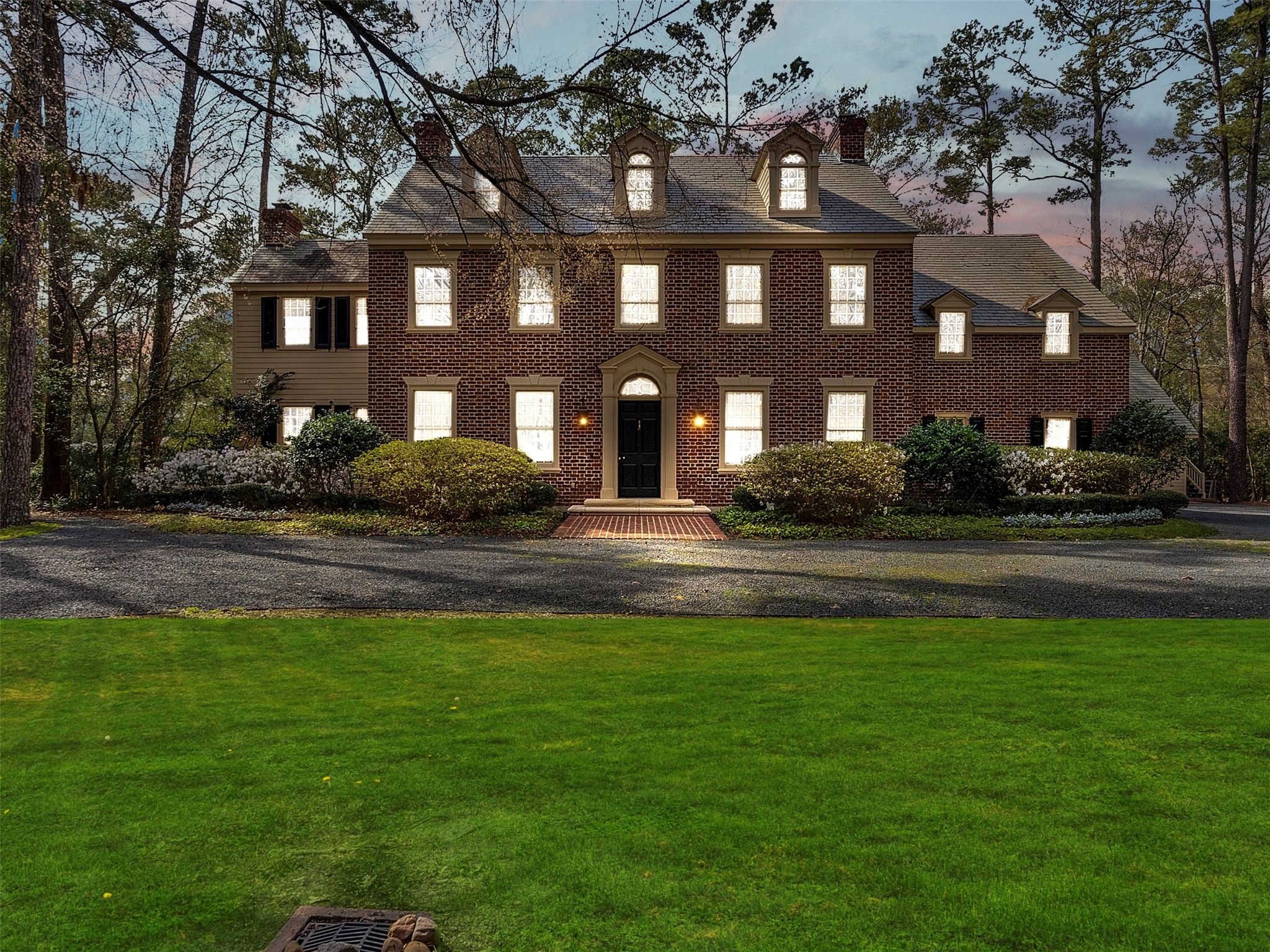 5212 Strack Road Houston, TX 77069 - Photo 2 of 42 The architectural beauty of this Federalist estate is best realized at twilight, as professional lighting illuminates the artisan textures of the brickwork. An oversized circular driveway provides an impressive approach for guests, complemented by a spacious three-car garage that offers both convenience and ample storage for the discerning homeowner