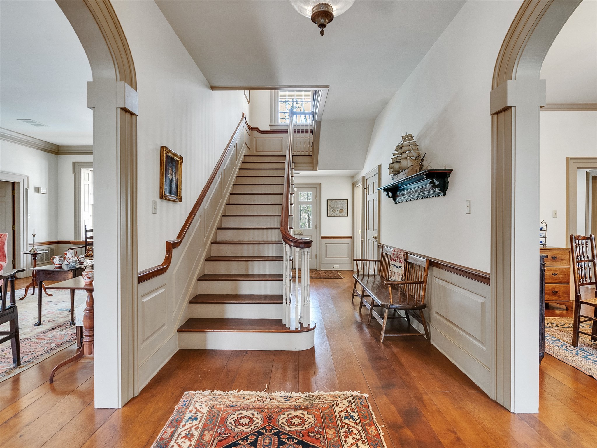5212 Strack Road Houston, TX 77069 - Photo 3 of 42 The foyer makes a striking first impression with its custom staircase, rich hardwoods, and classic wainscoting. Timeless Federalist details and wide arched openings create an inviting sense of scale and craftsmanship.