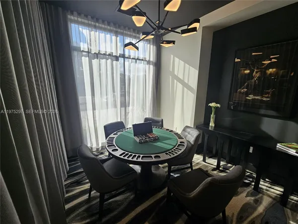 a living room with furniture a chandelier and pool table