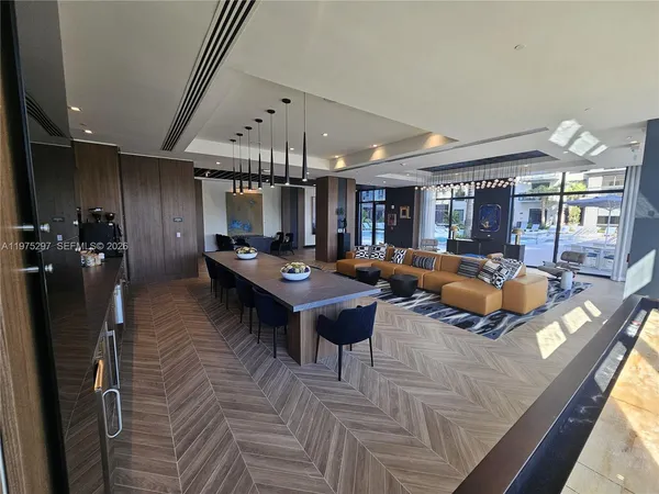 a living room with furniture a flat screen tv and kitchen view