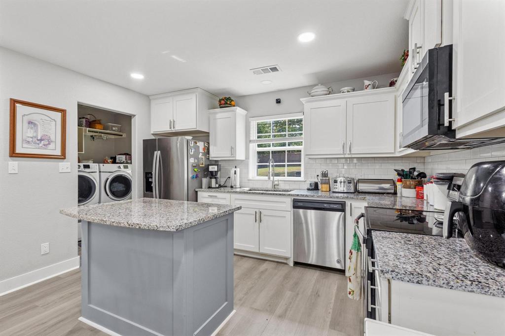 608 East Shepherd Street Denison, TX 75021 - Photo 13 of 31 a kitchen with stainless steel appliances granite countertop a sink dishwasher stove top oven and refrigerator