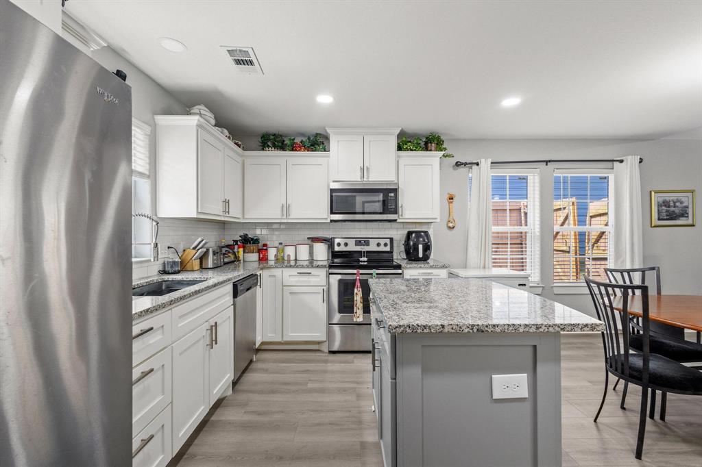 608 East Shepherd Street Denison, TX 75021 - Photo 14 of 31 a large kitchen with stainless steel appliances granite countertop a stove refrigerator and a view of living room