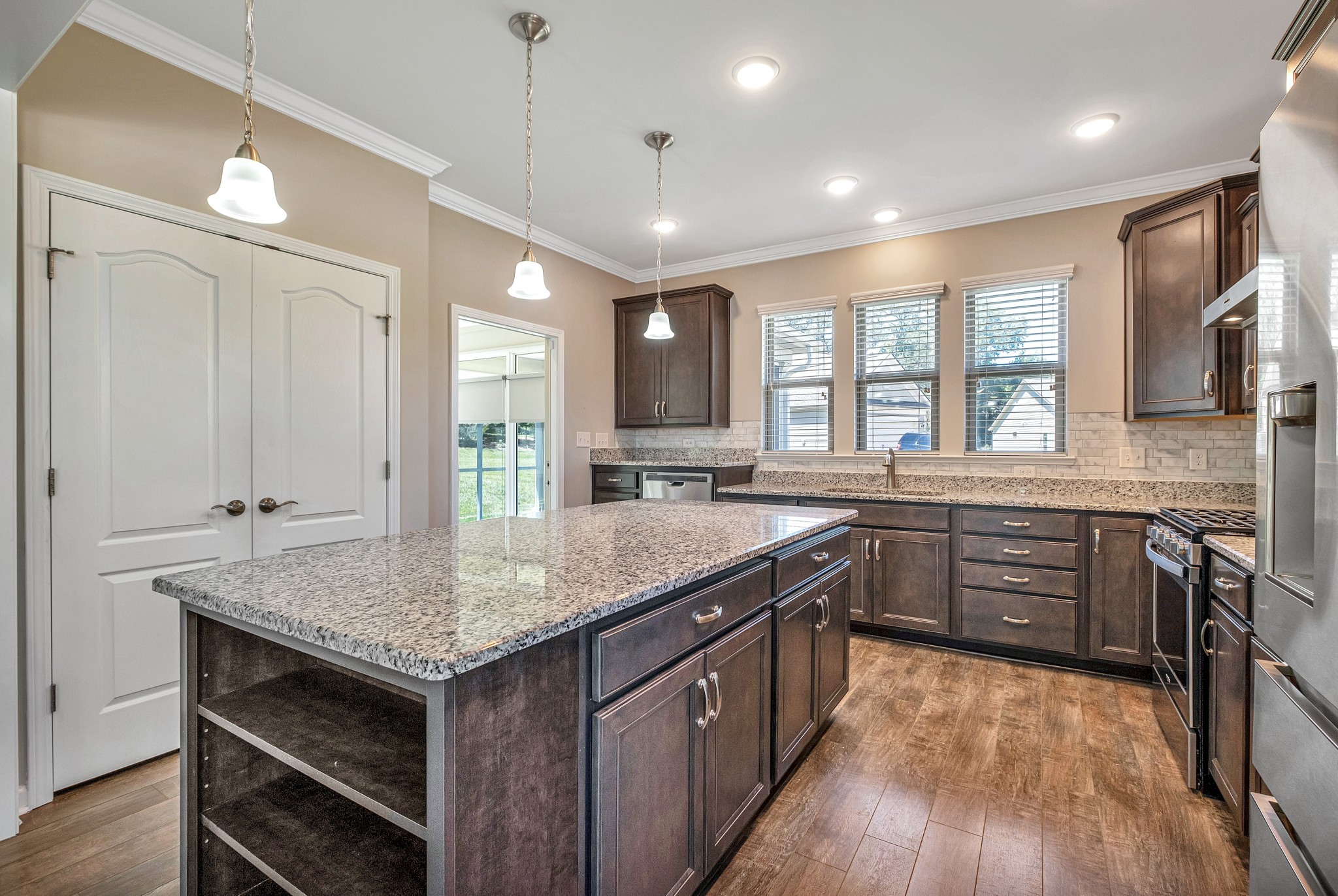 104 Tipton Pass Spring Hill, TN 37174 - Photo 16 of 57 a kitchen with granite countertop center island wooden floor and stainless steel appliances