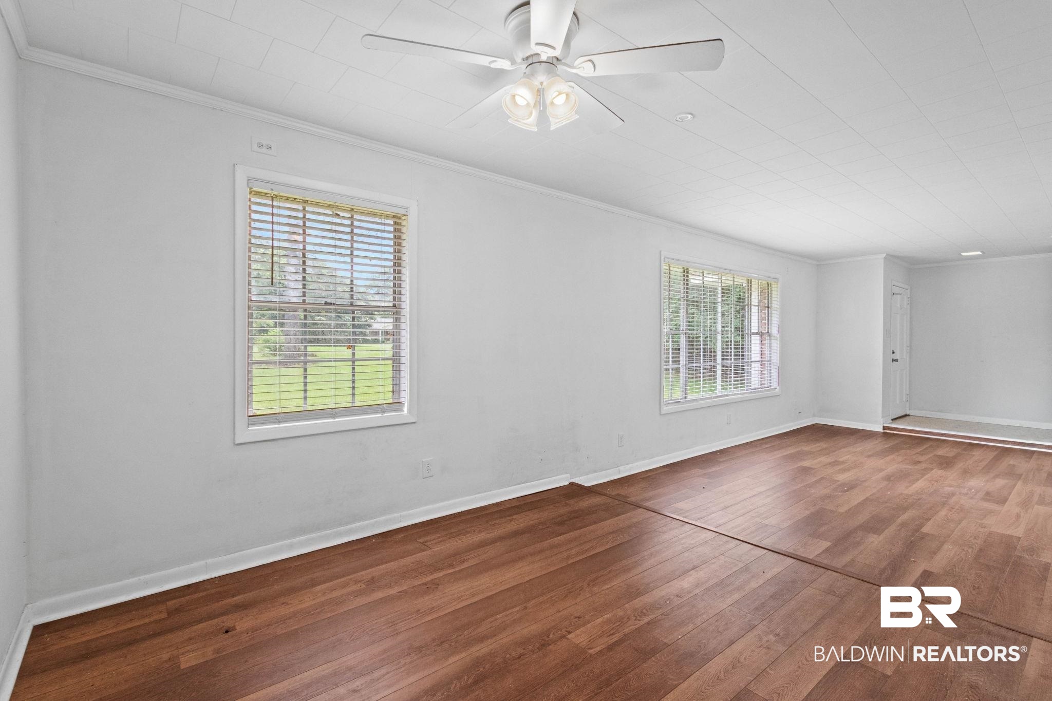 384 Old Bratt Road Atmore, AL 36502 - Photo 28 of 64 Spacious interior with wood-finish flooring, white walls, and two large windows