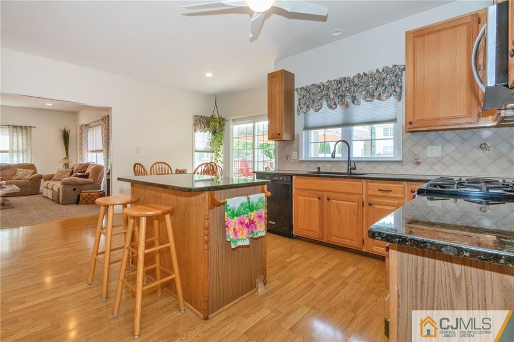 15 Crescent Road Old Bridge, NJ 08857 - Photo 4 of 19 a kitchen with stainless steel appliances granite countertop a stove a sink dishwasher and a dining table with cabinets