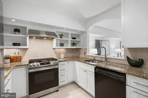 a kitchen with stainless steel appliances granite countertop a sink stove and cabinets