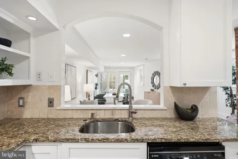 a kitchen with granite countertop a sink and a stove