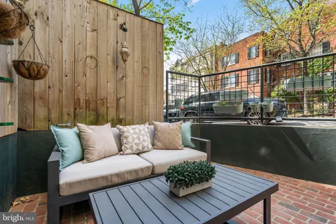 a roof deck with couches and potted plants