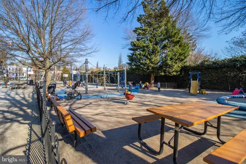 a view of a street sign under a large tree