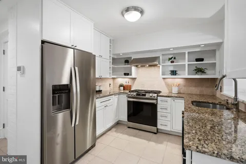 a kitchen with stainless steel appliances granite countertop a refrigerator sink and stove